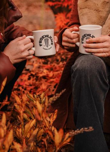 two people holding coffee cups in their hands at The Neighborhood Hotel Grand Beach in New Buffalo