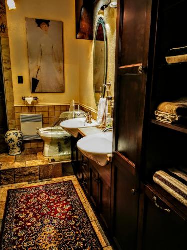 a bathroom with two sinks and a toilet and a rug at Auberge J.A Moisan in Quebec City
