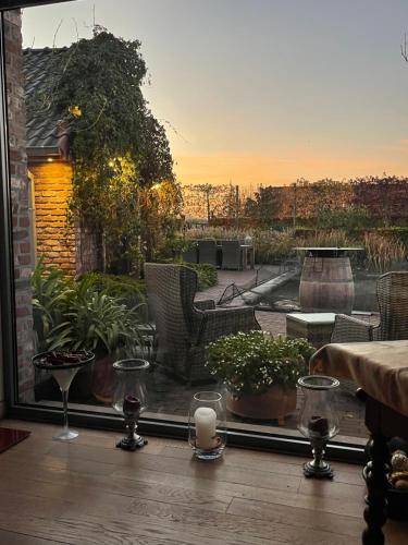 a balcony with a view of a garden with a table and candles at Parel van Bever - Perle de Biévène in Bever