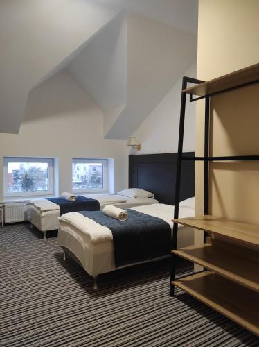 a hotel room with two beds and two windows at B&B Panevėžys in Panevėžys