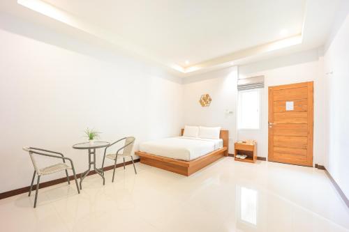 a bedroom with a bed and a table and chairs at AKARD Private Villas Sattahip in Sattahip