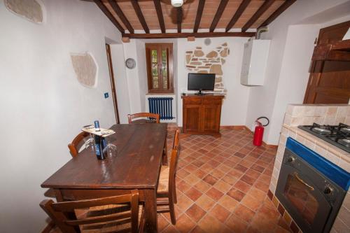 a kitchen with a wooden table and a dining room at Il Borgo Del Lupo Relax Family Apartments in Tuscany with Restaurant & Swimming Pool in Sarteano