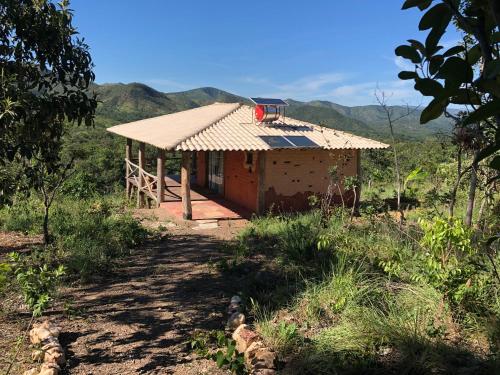 a small house with a roof on a hill at Ecopousada Toca do Guará in Alto Paraíso de Goiás