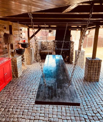 a swing in a pavilion with a pool of water at Casa Pisica Noastra in Breaza