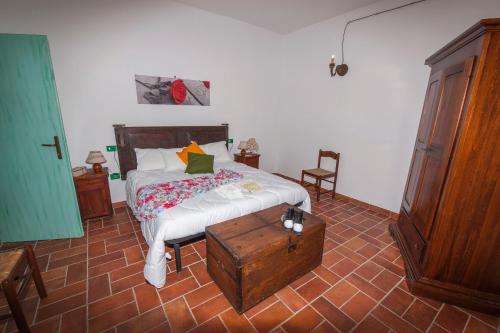 a bedroom with a bed and a wooden dresser at Il Borgo Del Lupo Relax Family Apartments in Tuscany with Restaurant & Swimming Pool in Sarteano