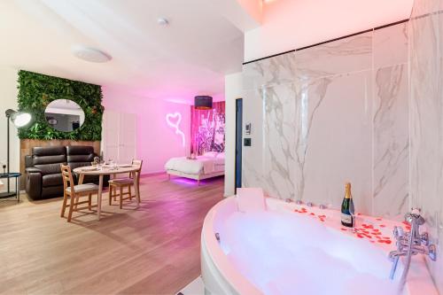 a bathroom with a tub and a dining room with a table at Aurora Lov'Room Proche de Saint Charles in Marseille