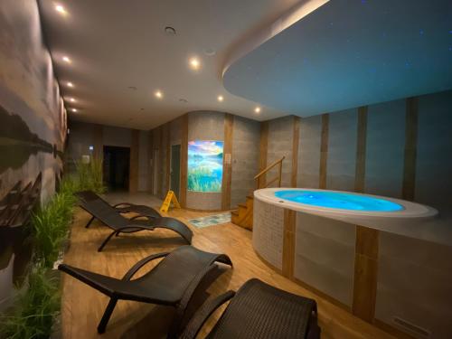 a wellness room with a hot tub and chairs at Centrum Rekreacji U Stolema in Ostrzyce