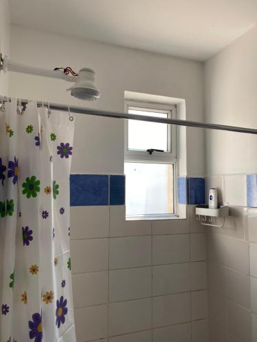 a bathroom with a shower curtain with flowers on it at Lyshima’s Cozy Studio in Nairobi