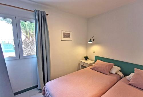 una camera con letto e finestra di Calypso, apartamento completo con vistas al mar y a la piscina en Costa Teguise a Costa Teguise