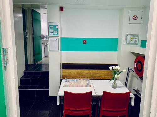 a kitchen with a table, chairs and a refrigerator at The White Tulip Hostel in Amsterdam