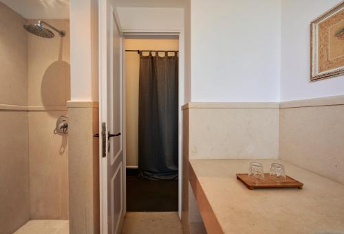 a bathroom with two wine glasses on a counter at Varaba Country House in Markopoulo