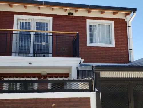 a red brick building with a balcony on it at MAR & ARENA in Puerto Madryn