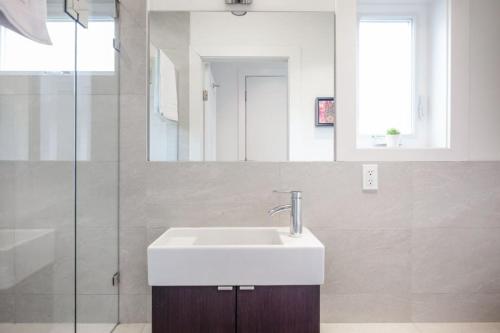 a bathroom with a white sink and a shower at West Coast Luxury Living in Vancouver