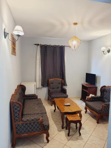 a living room with two chairs and a table at Hôtel Altitel in Bafoussam