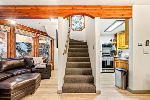 a living room with a staircase and a couch at Cozy Tree & Ski House in Girdwood