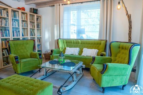 sala de estar con 2 sillas verdes y mesa en Agroturystyka Corno Owca en Żabnica