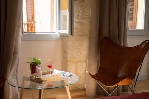 a room with a glass table and a chair and a window at Locanda Carra Manna in Sassari