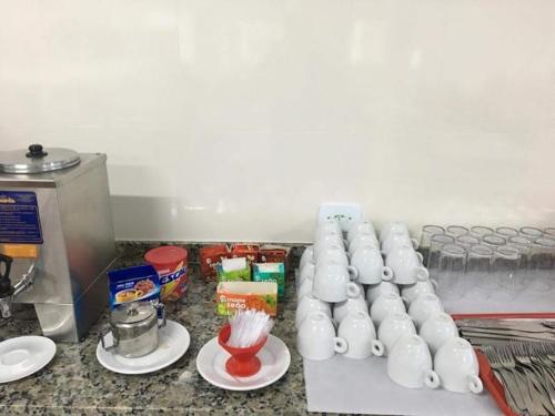 een aanrecht met een aantal piepschuimbekers bovenop een keuken bij Colônia de Férias SITRAEMFA in Peruíbe