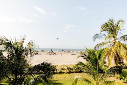 a beach with palm trees and people on the beach at Hermoso apartamento con todas las comodidades acceso directo a la playa ubicado en el edificio Morros Epic in Cartagena de Indias