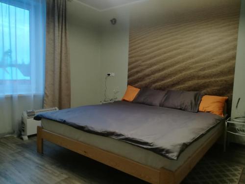 a bed with a wooden headboard in a bedroom at Oāze Smiltenē in Smiltene