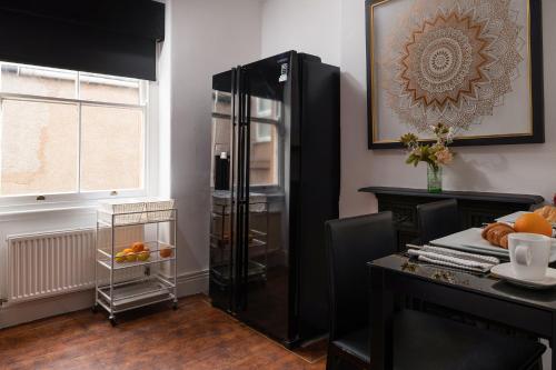 a black refrigerator in a room with a table at The North Shore in Llandudno
