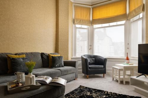 a living room with a couch and a tv at The North Shore in Llandudno