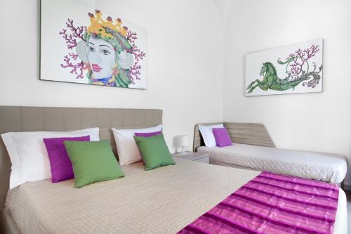 1 dormitorio con 2 camas con almohadas moradas y verdes en Estate4Home - Villa Lina en Sant'Agnello