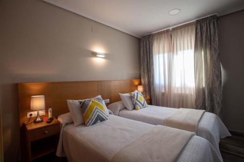 pokój hotelowy z 2 łóżkami i oknem w obiekcie PENSIÓN CASA ANTONIO w mieście Pantón
