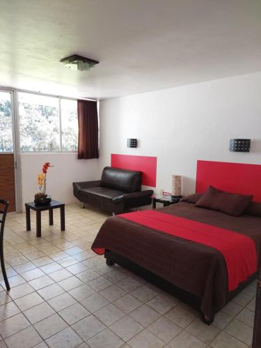 Un dormitorio con una cama grande y un sofá. en El Suueño Zacatlán, en Zacatlán