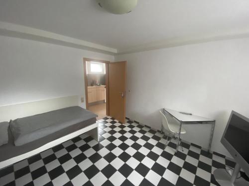 a bedroom with a bed and a checkered floor at Ihr Apartment in der Natur in Schwerte