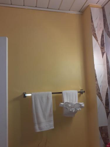 2 toallas colgando de un toallero en el baño en Essentials Suite, en Bon Accord