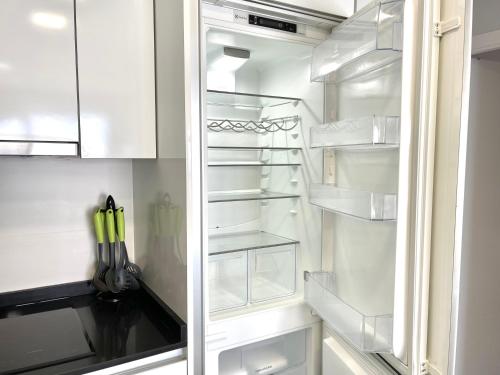 a white refrigerator with its door open in a kitchen at Exclusive Apartments on the first line of Benidorm Mar y Sol in Benidorm
