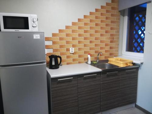 a kitchen with a stainless steel refrigerator and a sink at Oāze Smiltenē in Smiltene