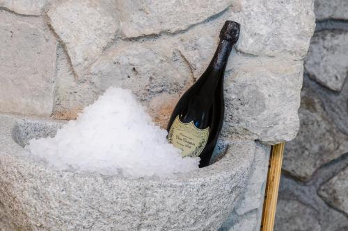 a bottle of wine next to a pile of snow at Hotel Ramon in Campitello di Fassa