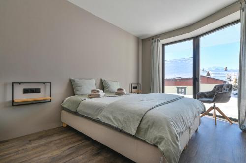 a bedroom with a bed and a large window at Dachstein Bock exkl Ferienwohnung vor der Piste in Russbach am Pass Gschütt