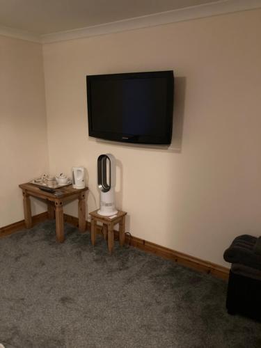a living room with a flat screen tv on the wall at Carland Cross in Newquay