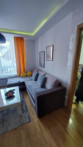 a living room with a couch and a table at apartman Kraljevi čardaci Sadikovic sa garažom in Kopaonik
