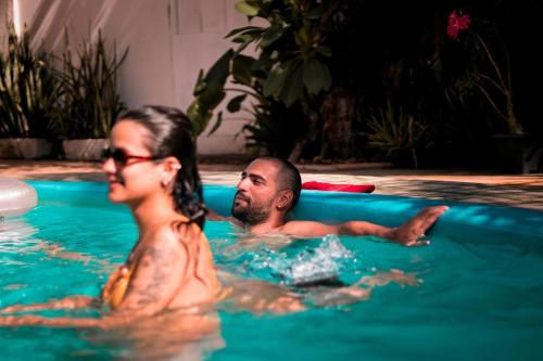 a man and a woman in a swimming pool at Tropical Hostel in Pipa