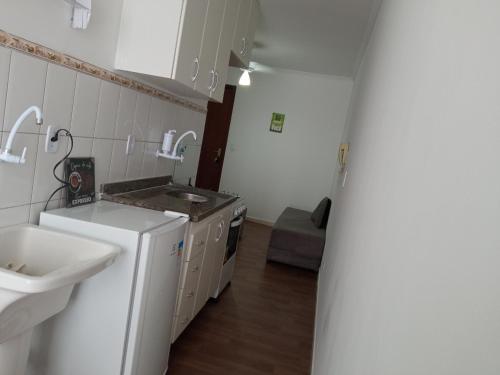 a small kitchen with a sink and a refrigerator at kit Catavento in Brasilia