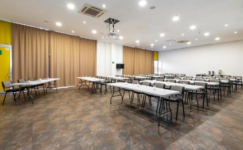 a conference room with tables and chairs and a podium at Pop Art Hotel CLC Puerto Mamonal Cartagena in Cartagena de Indias