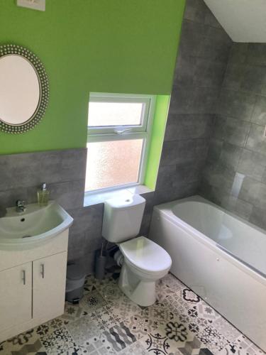 a bathroom with a toilet and a tub and a sink at Alexandra House in Goole