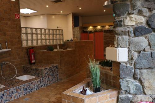 La salle de bains est pourvue d'un mur en pierre et d'une bouche de feu. dans l'établissement Berg-Blick-Fewo, à Bad Harzburg