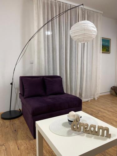 a living room with a purple couch and a table at Lilyy in Leskovac