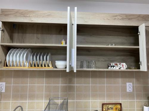 a kitchen cabinet with plates and bowls on it at Lilyy in Leskovac