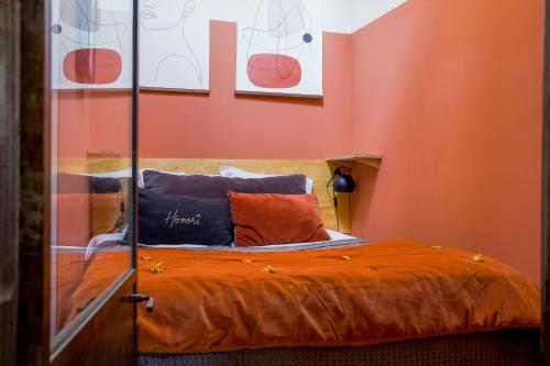 1 dormitorio con 1 cama con paredes de color naranja en HONORÊ - Suite Terracotta en Lyon