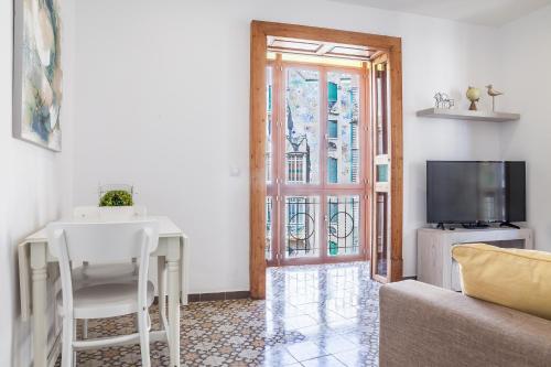 a living room with a table and a tv at Can Boss - Turismo de Interior in Palma de Mallorca