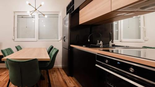 cocina con mesa de madera y sillas verdes en Apartment Black Diamond, en Ražanac