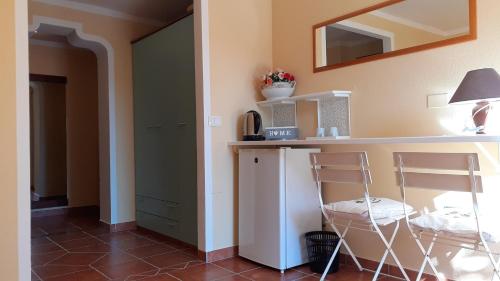 a kitchen with two chairs and a counter with a microwave at Li Muntigeddi in San Teodoro