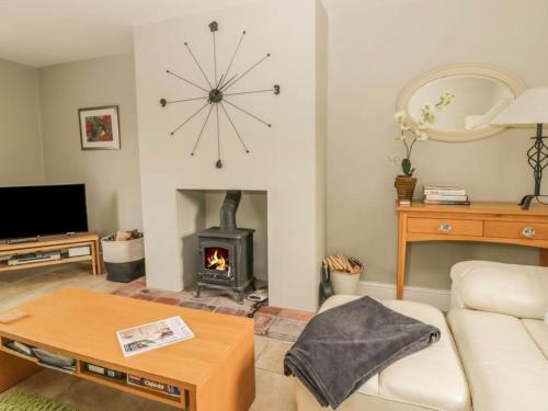 un soggiorno con camino e divano di New Station Cottage, country views, great location a Sledmere