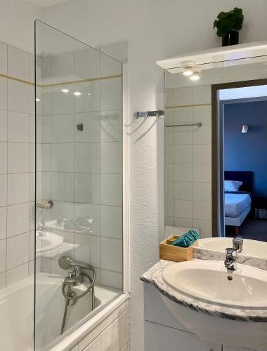 une salle de bain avec un lavabo et une douche en verre dans l'établissement Bel appartement cosy dans résidence avec piscine 5 minutes plage, à Messanges